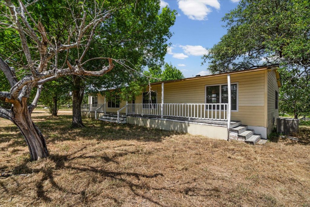 13501 Nutty Brown Road, Unit B Austin, TX 78737 - Photo 1 of 29 A quaint residential dwelling is surrounded by mature trees and natural landscaping.
