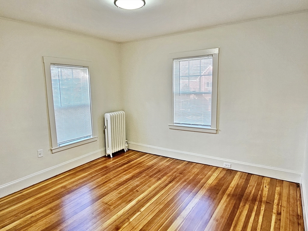 11 Channing Street, Unit 2 Newton, MA 02458 - Photo 11 of 33 a view of an empty room with wooden floor and a window