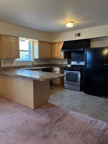 a kitchen with stainless steel appliances granite countertop a stove a sink and a microwave