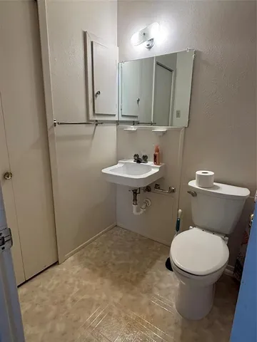 a bathroom with a toilet a sink and mirror