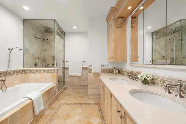 a bathroom with a tub sink shower and mirror