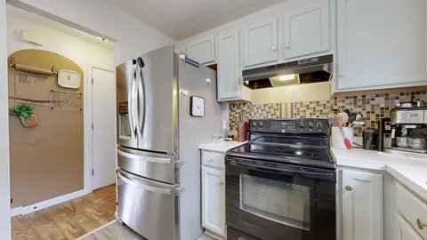 a kitchen with stainless steel appliances a stove a refrigerator and cabinets