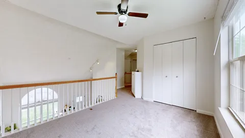a view of a hallway with a window and chandelier