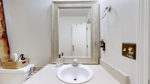 a bathroom with a toilet a sink and mirror