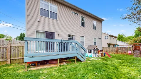 a view of a house with a wooden deck and a yard