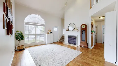 wooden floor with fireplace and a rug