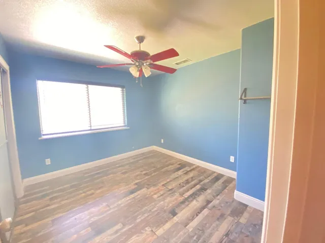 a view of a bedroom with a ceiling fan and a window