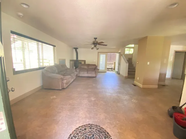a living room with fireplace furniture and a large window