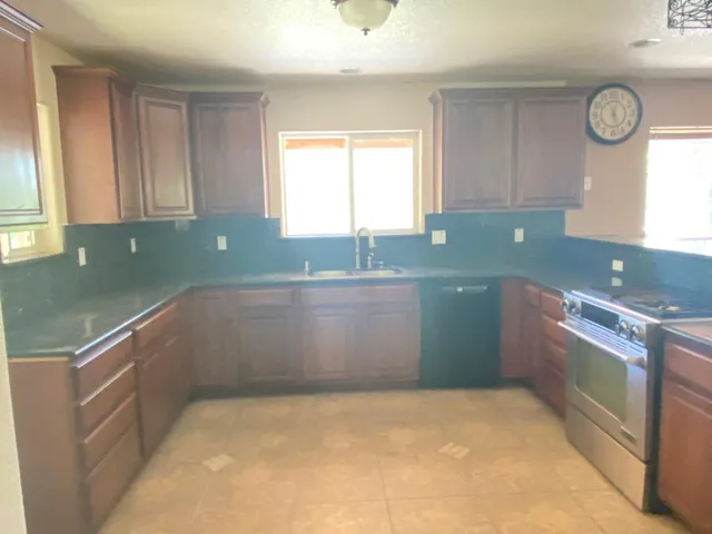 a kitchen with granite countertop a sink and a stove