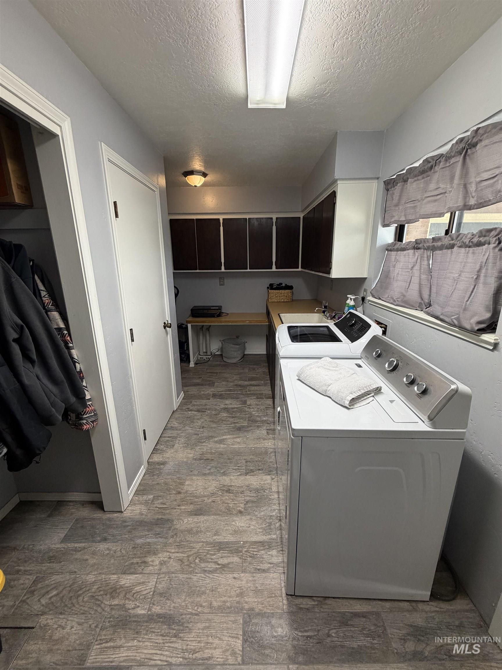 1452 Weiser River Road Weiser, ID 83672 - Photo 13 of 40 Laundry area with a textured ceiling, washing machine and dryer, and light wood-style flooring
