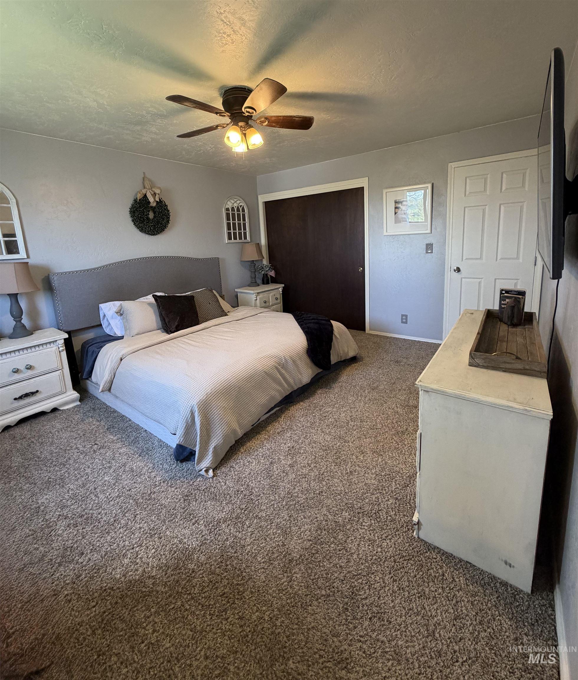 1452 Weiser River Road Weiser, ID 83672 - Photo 17 of 40 Carpeted bedroom with a closet, a ceiling fan, and a textured ceiling