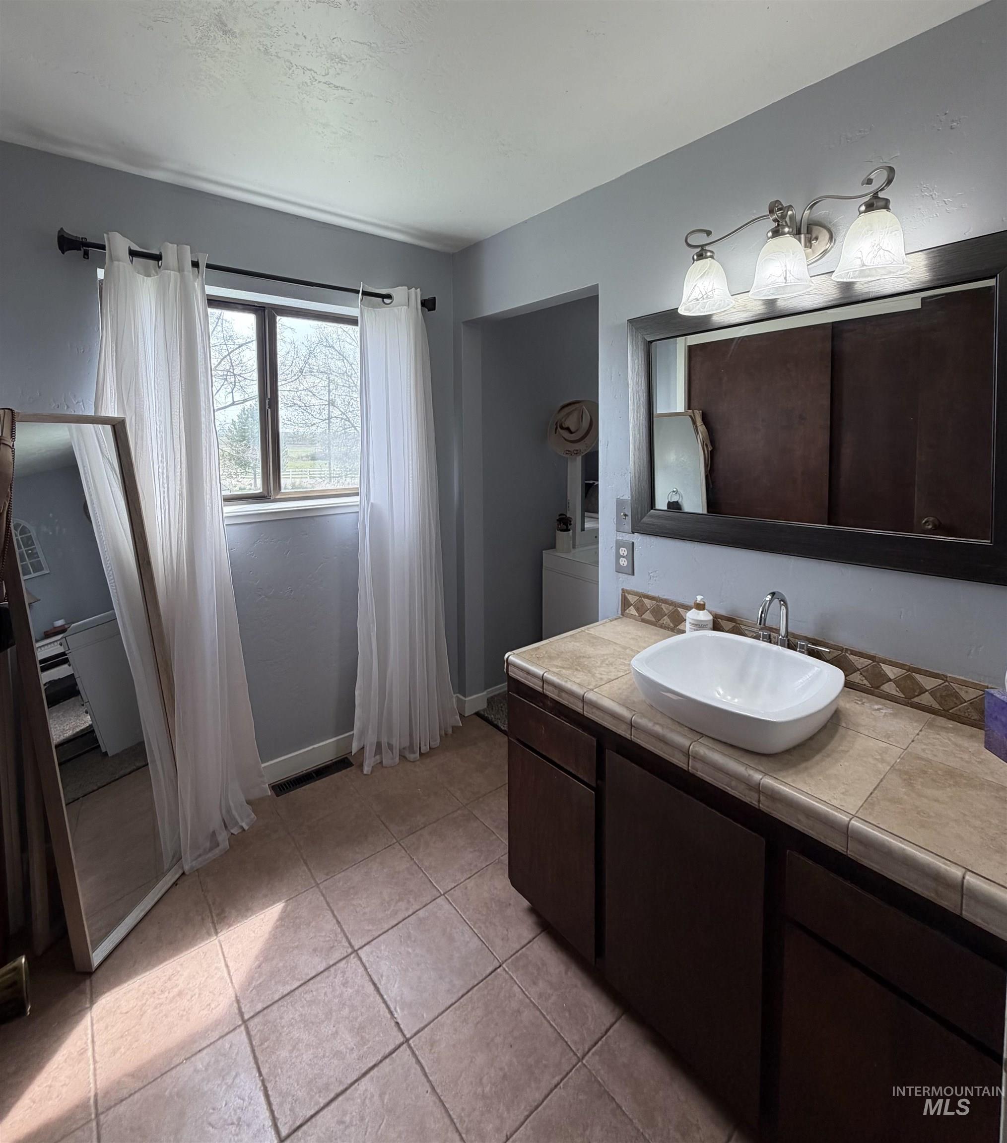 1452 Weiser River Road Weiser, ID 83672 - Photo 20 of 40 Bathroom featuring vanity and light tile patterned floors