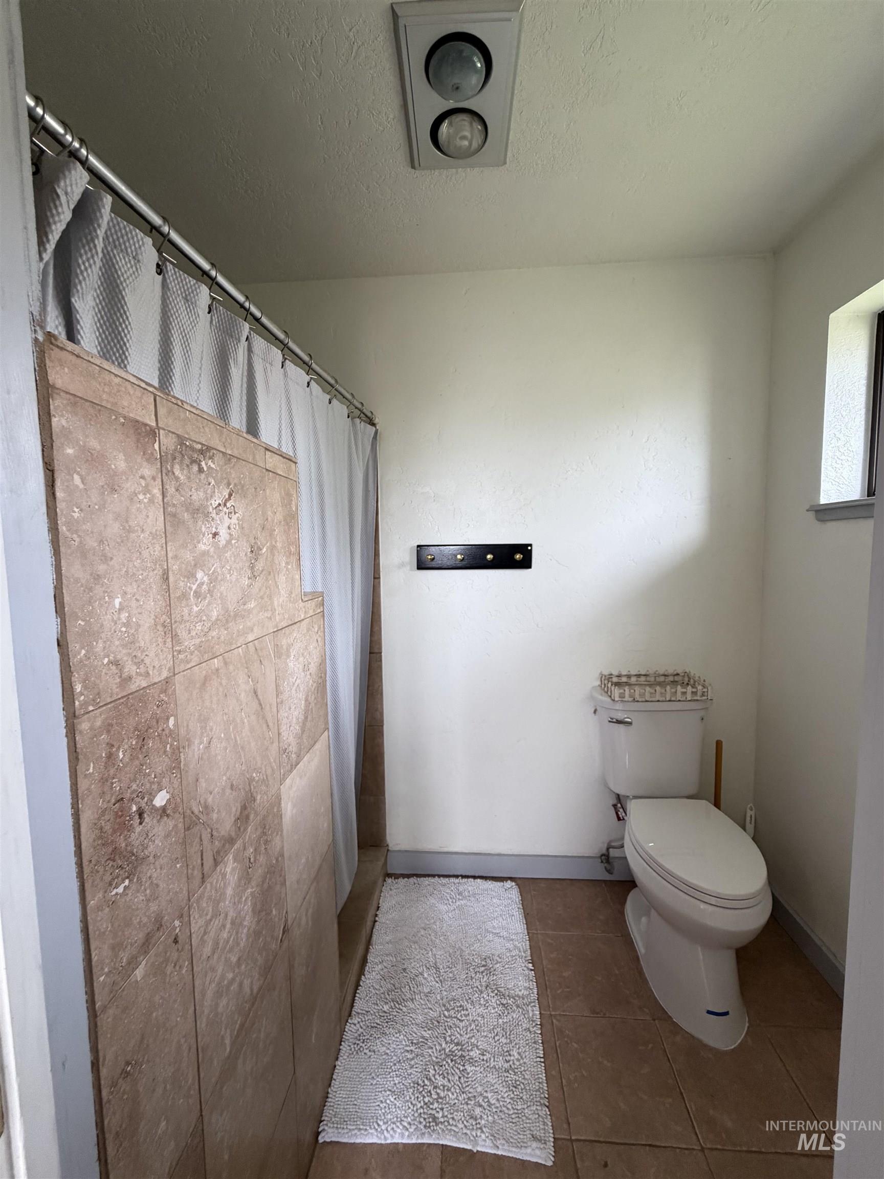 1452 Weiser River Road Weiser, ID 83672 - Photo 21 of 40 Bathroom with a stall shower, a textured ceiling, and tile patterned flooring