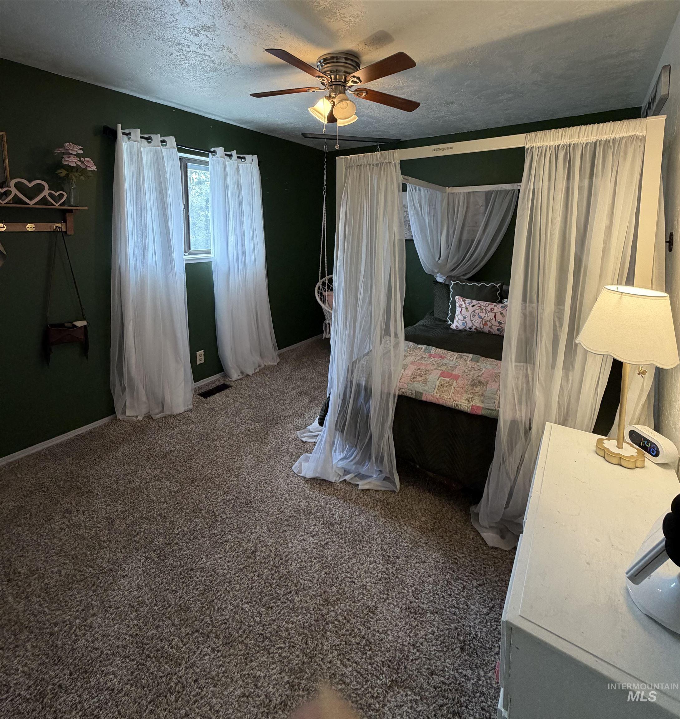 1452 Weiser River Road Weiser, ID 83672 - Photo 22 of 40 Bedroom with dark carpet, a ceiling fan, and a textured ceiling