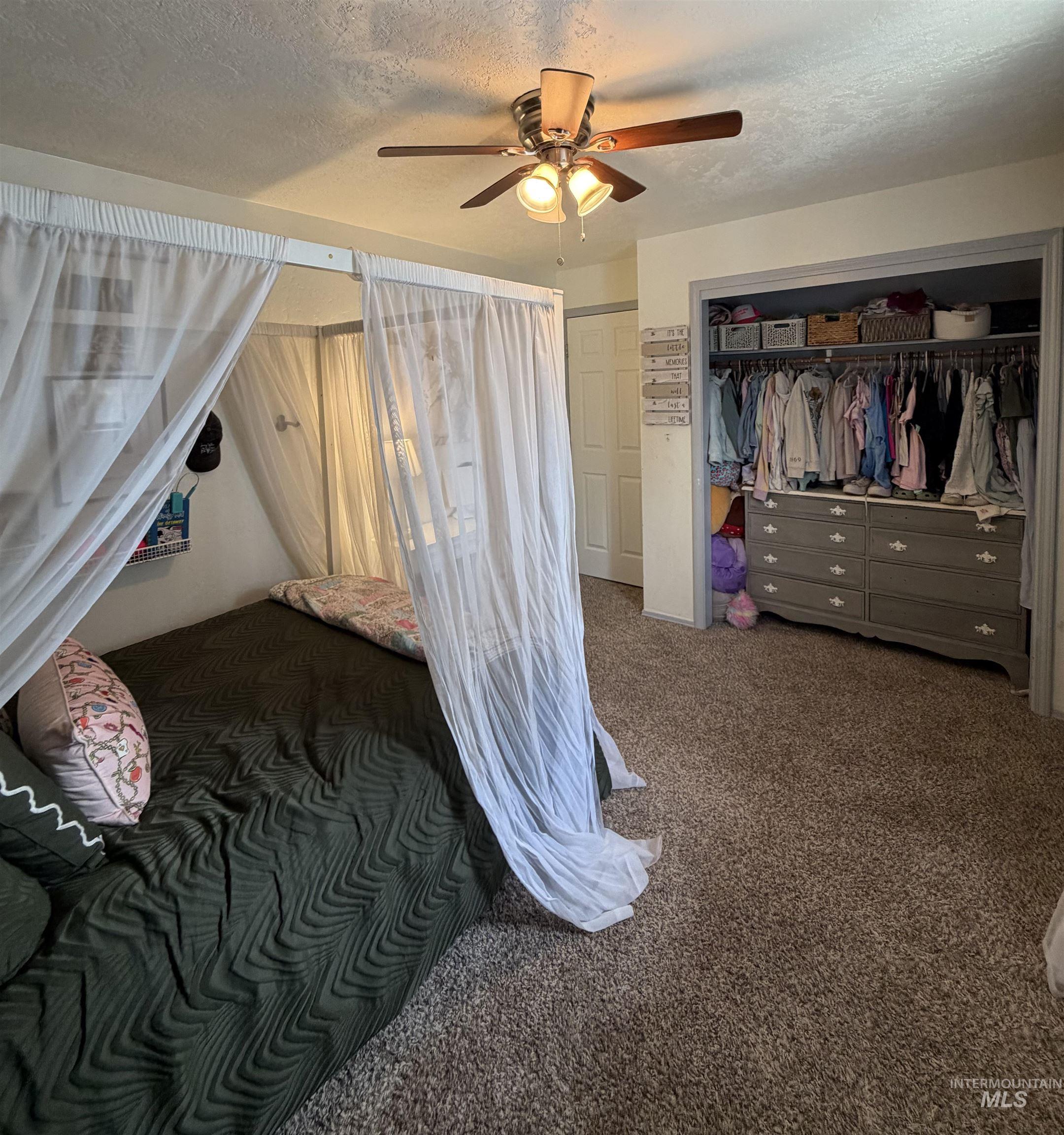 1452 Weiser River Road Weiser, ID 83672 - Photo 23 of 40 Bedroom featuring a textured ceiling, dark carpet, a closet, and ceiling fan