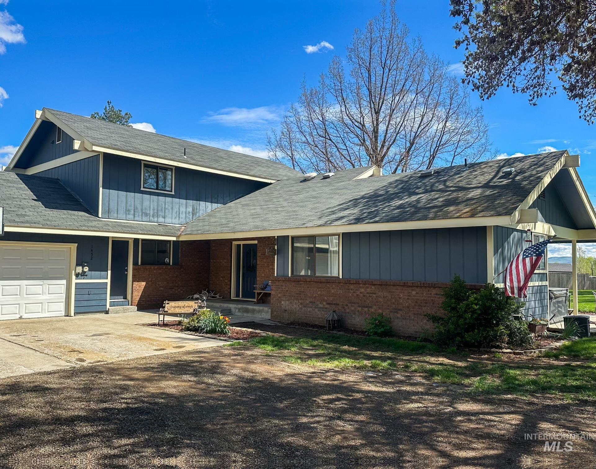 1452 Weiser River Road Weiser, ID 83672 - Photo 3 of 40 View of front facade with a garage, roof with shingles, brick siding, and driveway