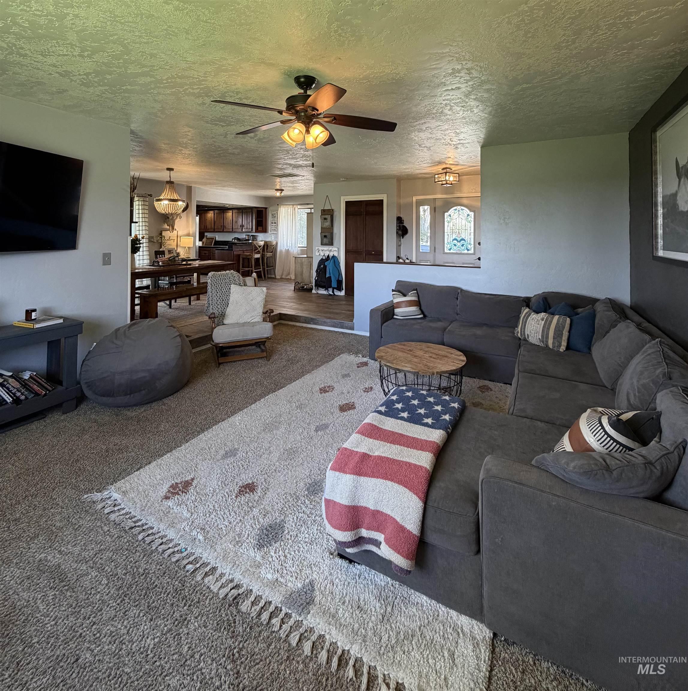 1452 Weiser River Road Weiser, ID 83672 - Photo 5 of 40 Carpeted living area with a textured ceiling and a ceiling fan