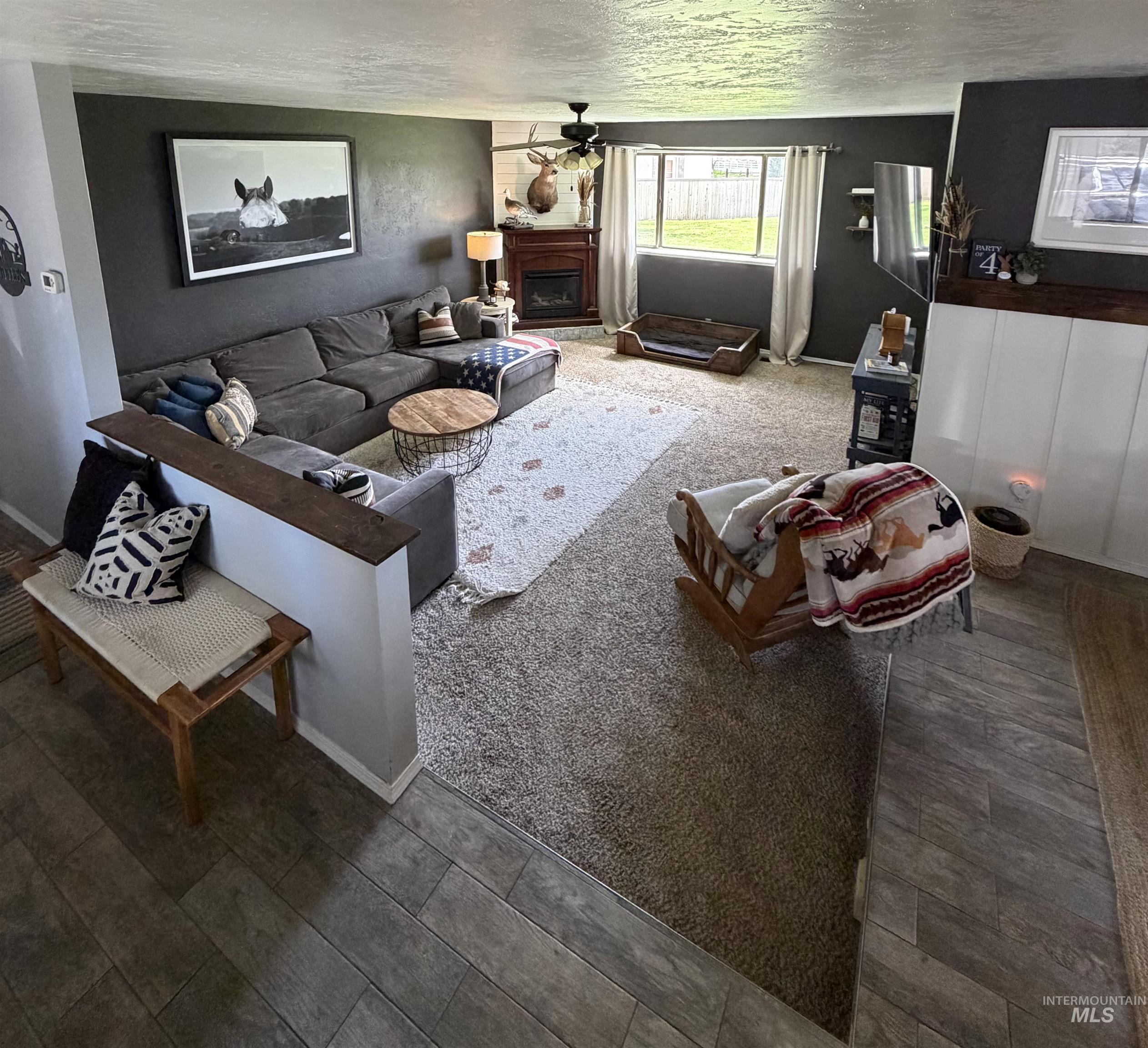 1452 Weiser River Road Weiser, ID 83672 - Photo 6 of 40 Living area with a fireplace, ceiling fan, and a textured ceiling