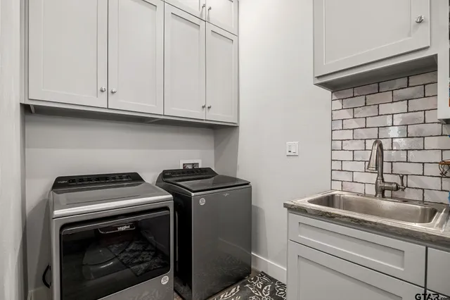 a kitchen with granite countertop white cabinets and a stove top oven