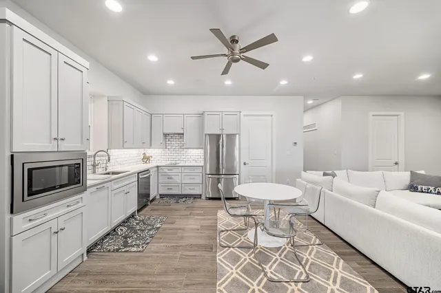 a large white kitchen with a stove a sink and a refrigerator