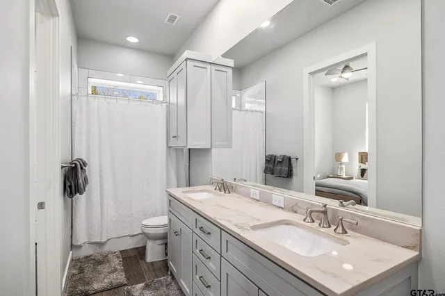 a bathroom with a granite countertop sink toilet and shower