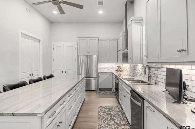 a kitchen with white cabinets and stainless steel appliances