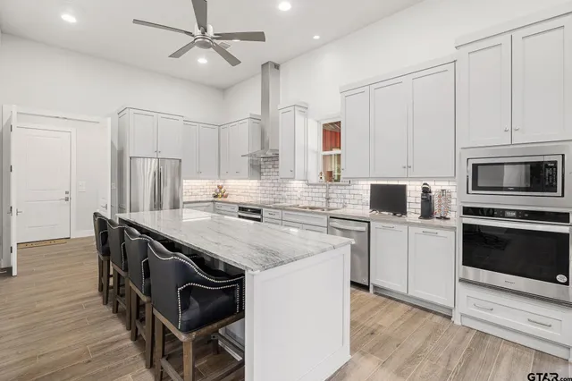 a kitchen with granite countertop a sink appliances cabinets and wooden floor