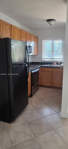 a kitchen with granite countertop a refrigerator and a sink
