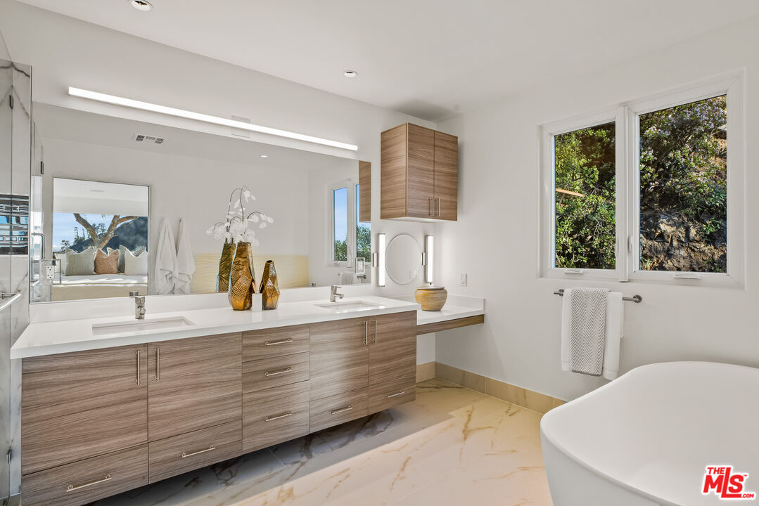 2201 Malaga Road Los Angeles, CA 90068 - Photo 36 of 51 a bathroom with a double vanity sink a large mirror a bathtub and window