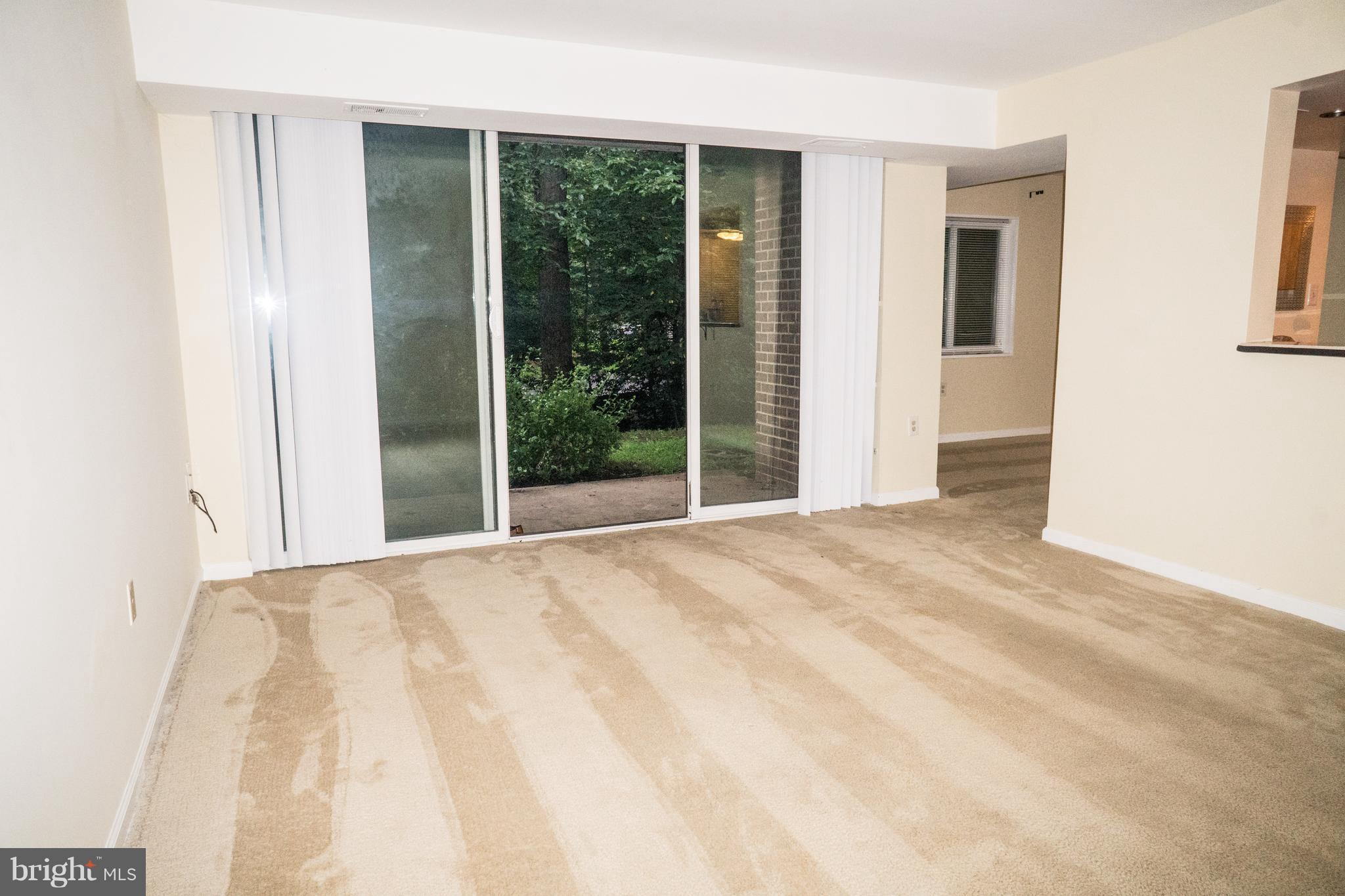 1413 Northgate Square, Unit 1C Reston, VA 20190 - Photo 6 of 16 Open Living Room Walk Out to Patio w Trees