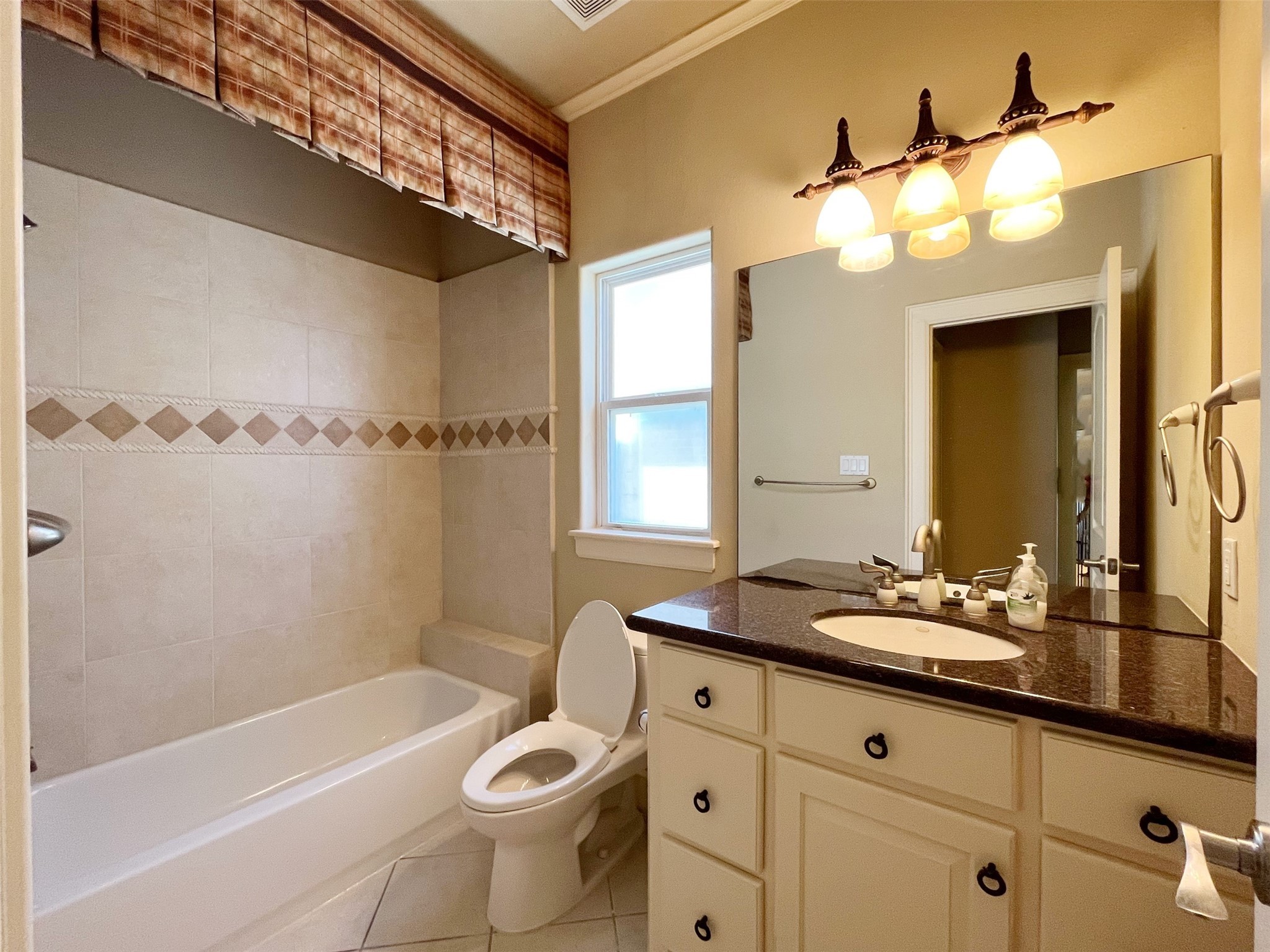 5455 Hidalgo Street Houston, TX 77056 - Photo 19 of 22 a bathroom with a granite countertop sink a toilet a mirror a bathtub and shower