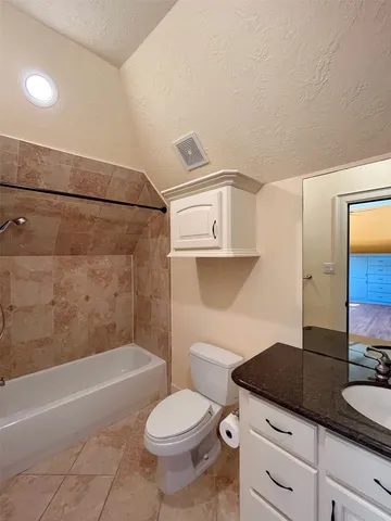 a bathroom with a granite countertop sink a toilet a mirror and bathtub