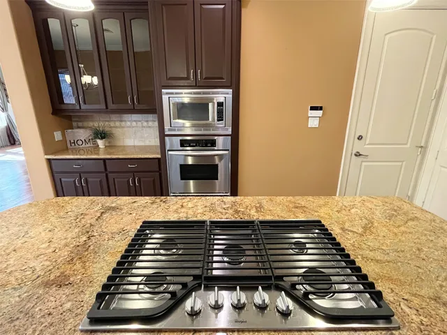 a kitchen with wooden cabinets and a stove top oven