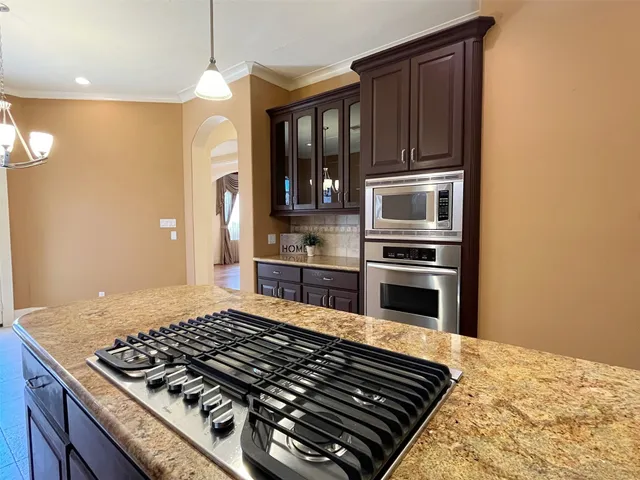 a kitchen with wooden cabinets and stainless steel appliances