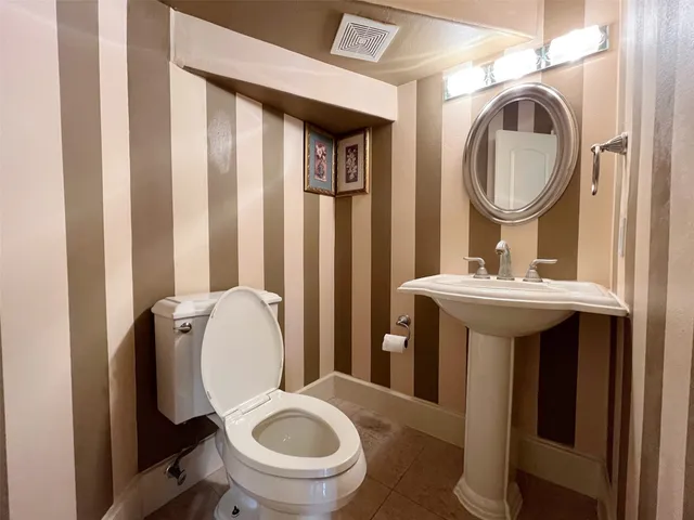 a bathroom with a sink mirror toilet and a window