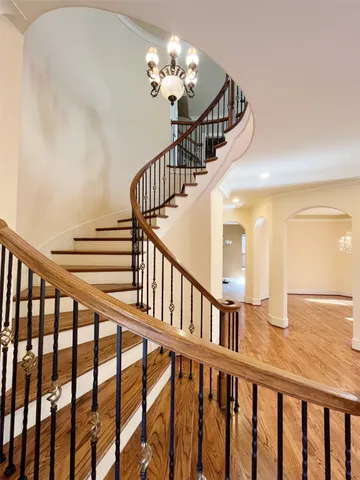 a view of staircase with wooden floor and fan