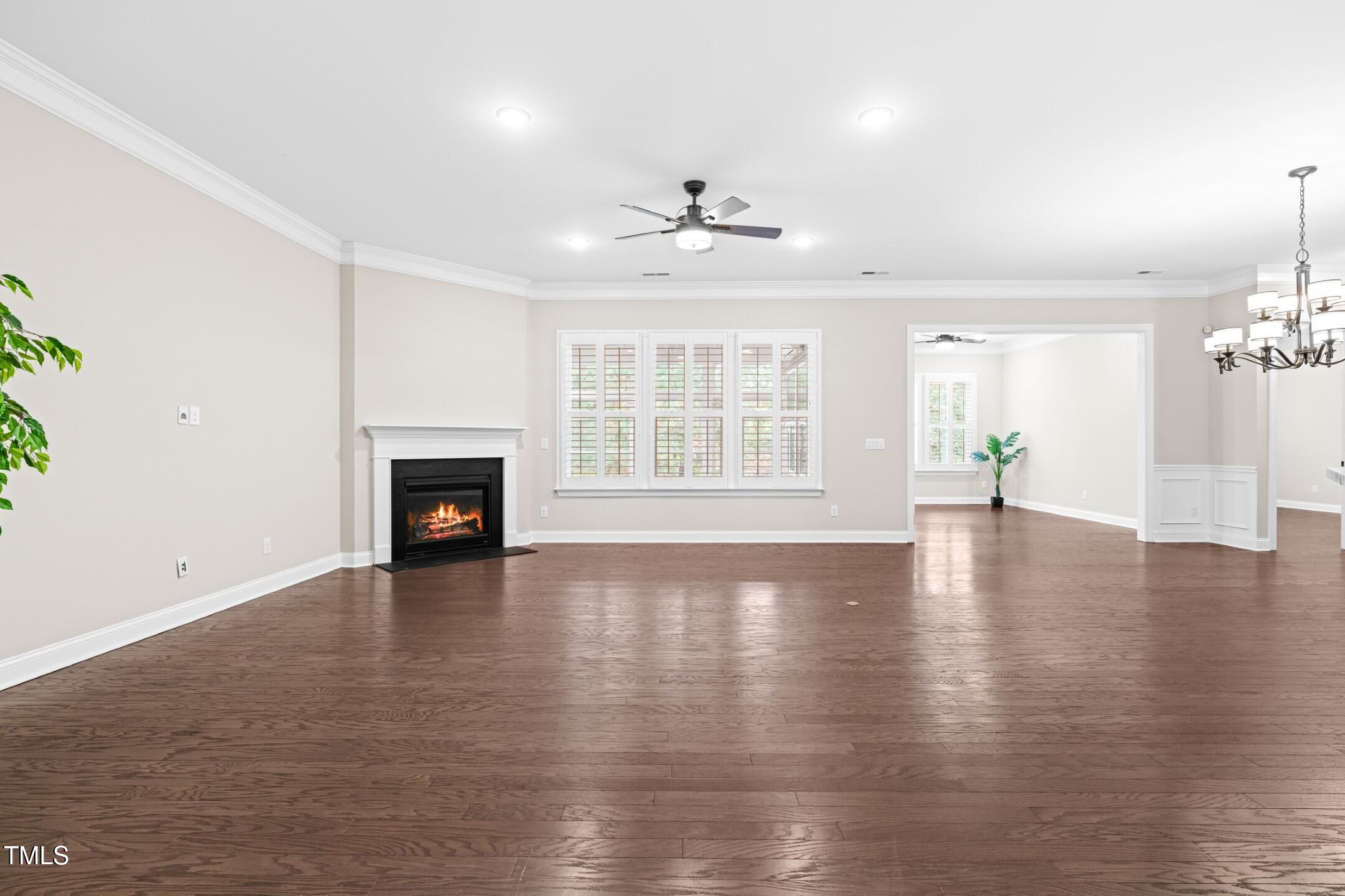 128 Damsire Way Cary, NC 27513 - Photo 14 of 45 an empty room with wooden floor fireplace and windows