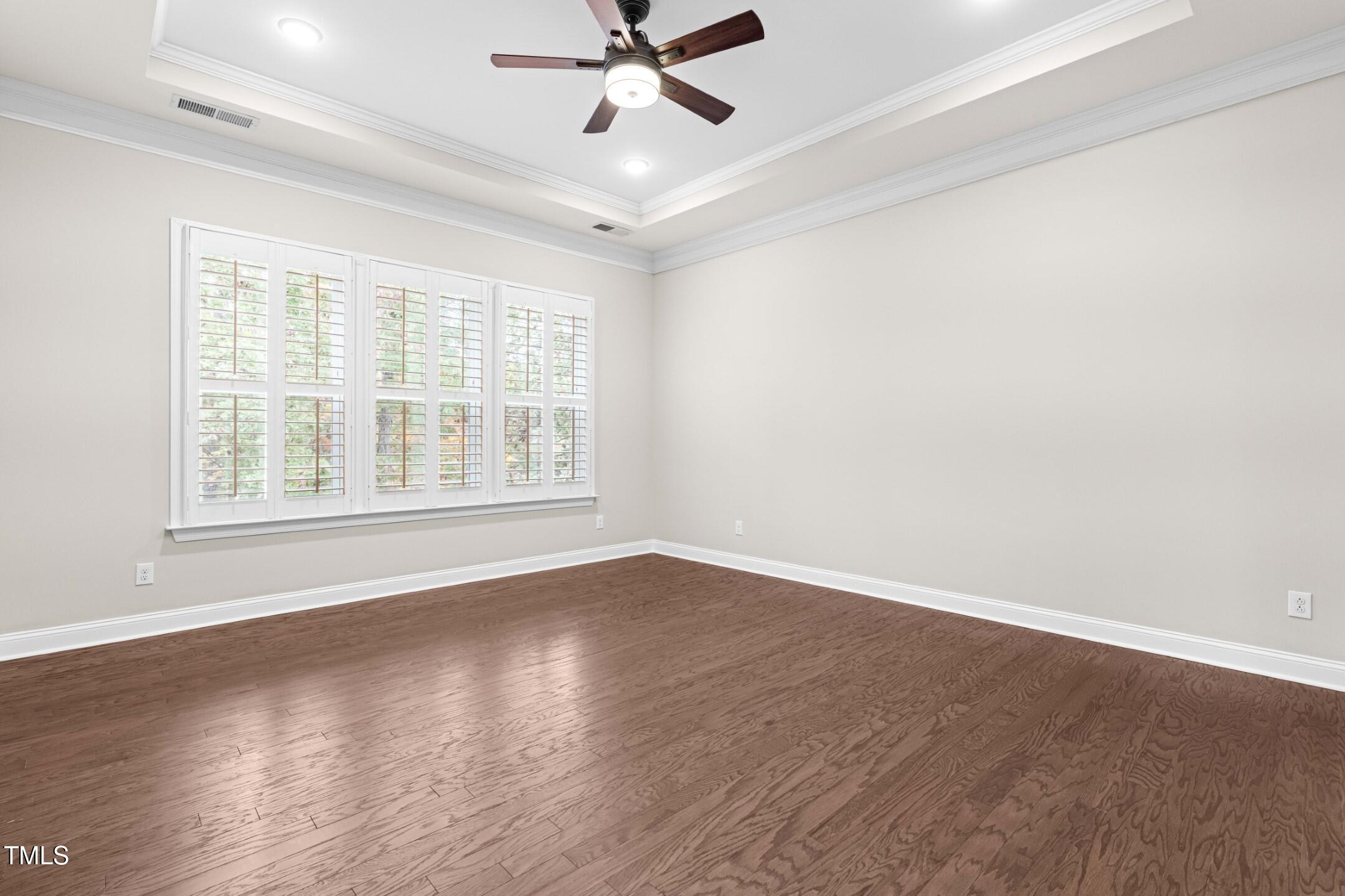 128 Damsire Way Cary, NC 27513 - Photo 26 of 45 an empty room with wooden floor fan and windows