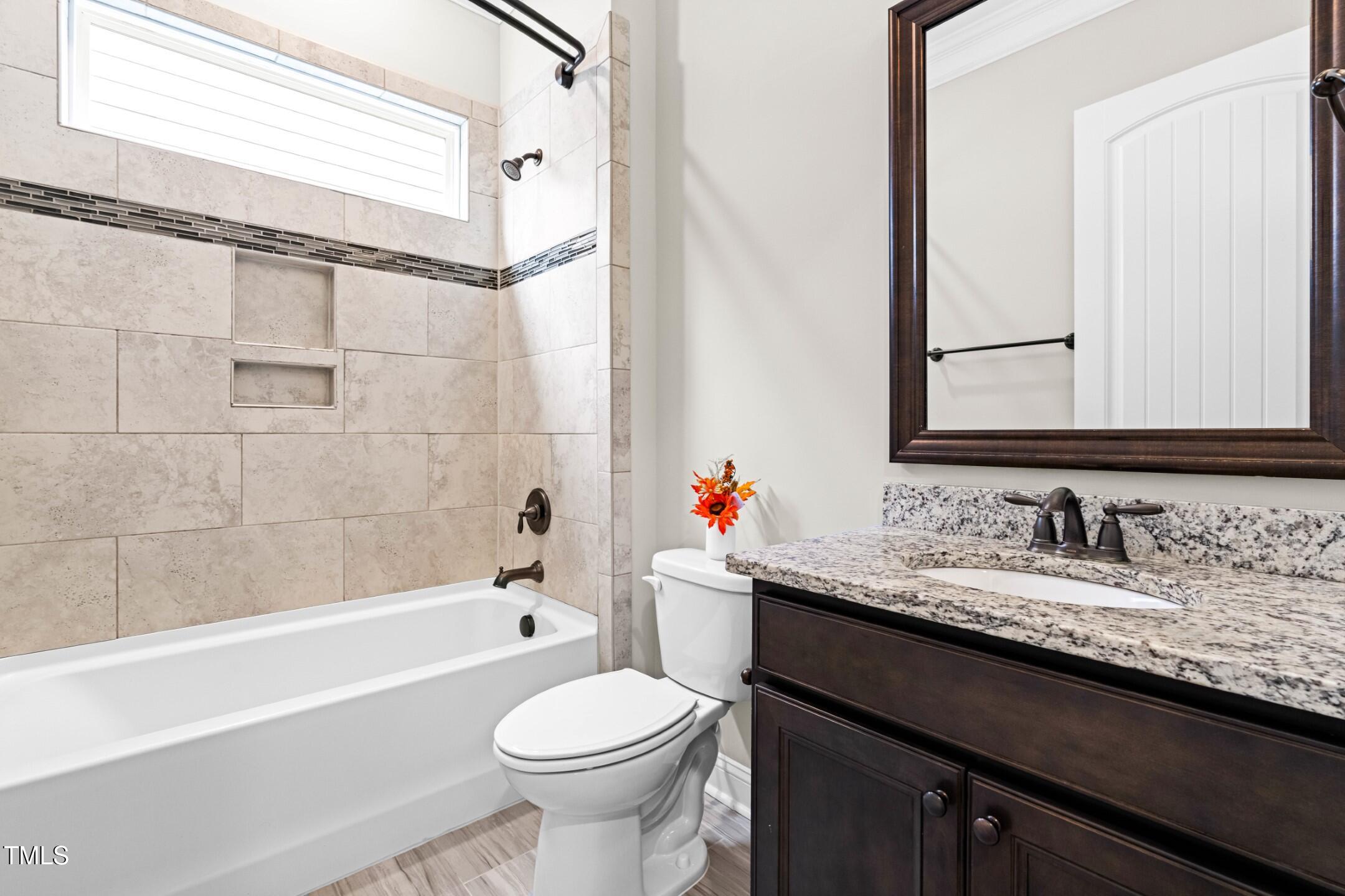 128 Damsire Way Cary, NC 27513 - Photo 32 of 45 a bathroom with a granite countertop bathtub sink vanity mirror and toilet