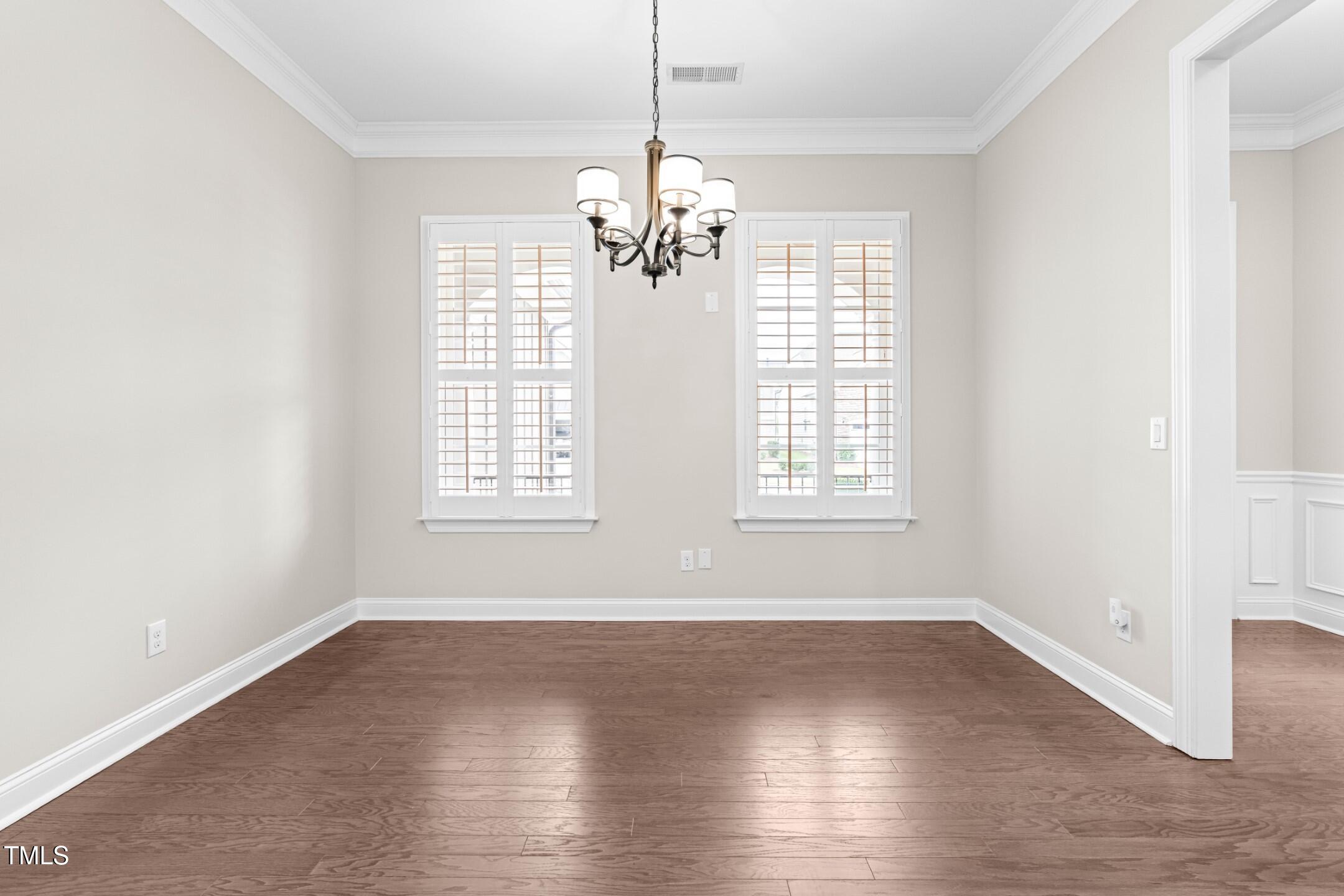 128 Damsire Way Cary, NC 27513 - Photo 5 of 45 an empty room with wooden floor and windows