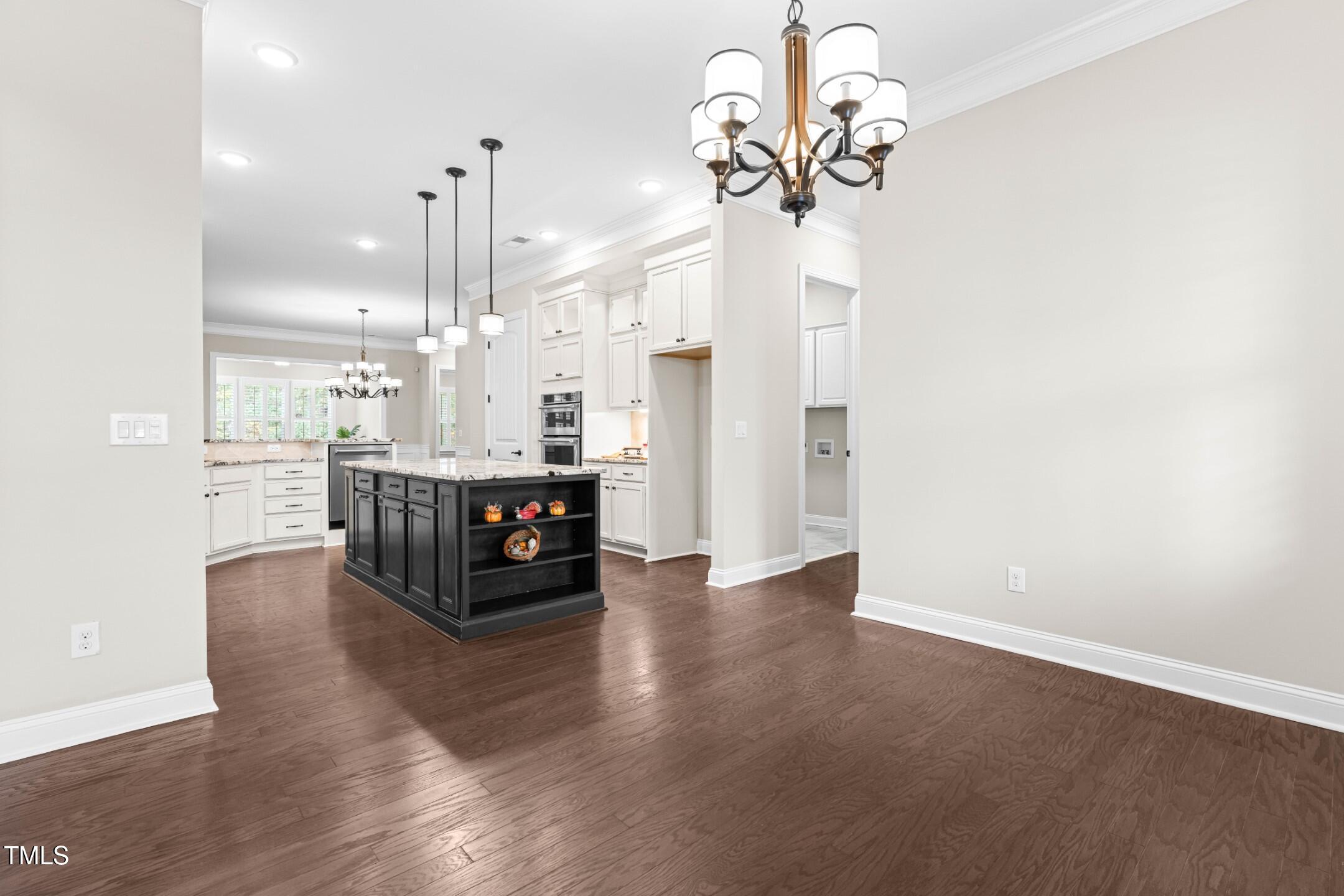 128 Damsire Way Cary, NC 27513 - Photo 6 of 45 a large kitchen with stainless steel appliances a large counter top a chandelier and a view of kitchen
