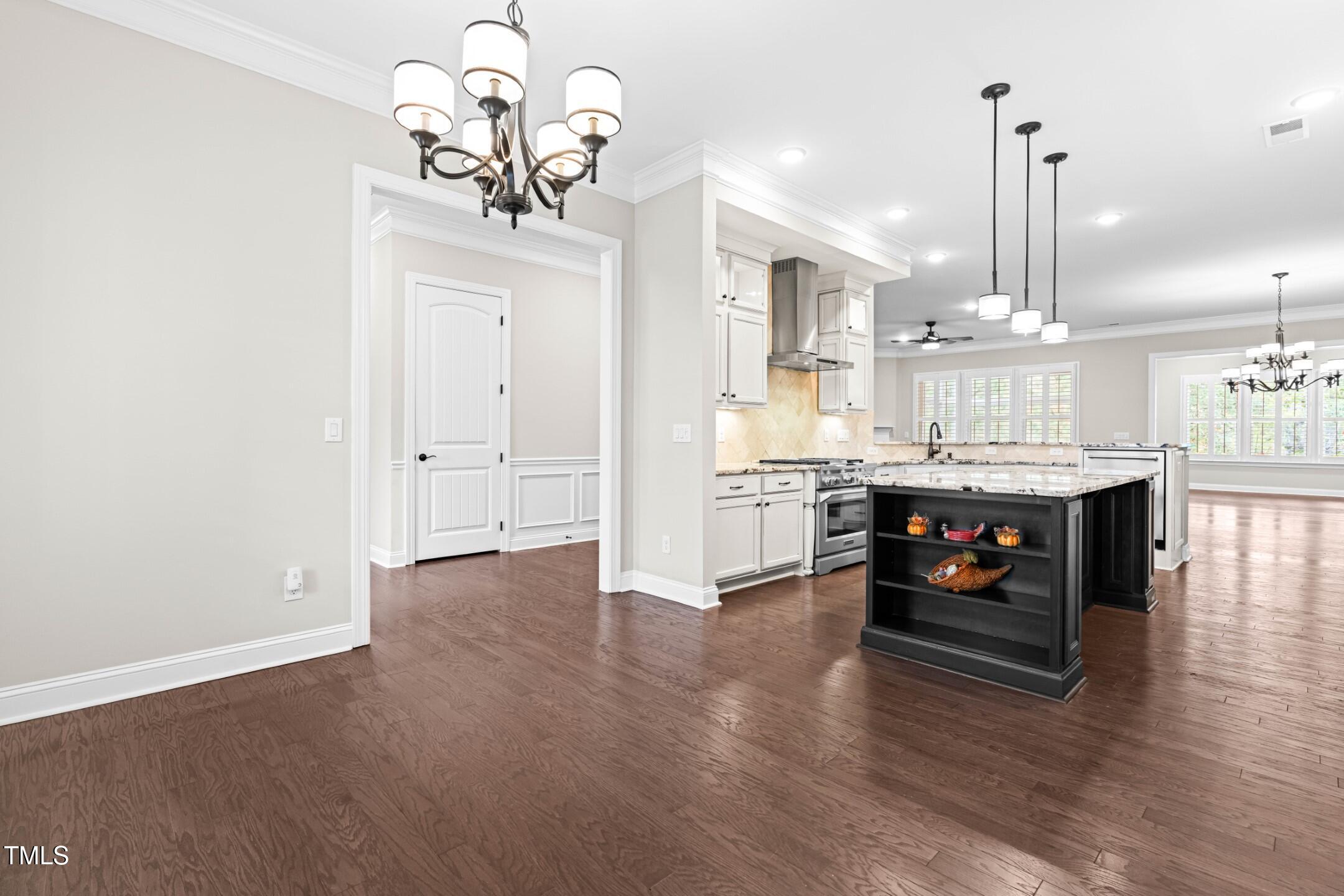 128 Damsire Way Cary, NC 27513 - Photo 7 of 45 a living room with stainless steel appliances kitchen island granite countertop a stove a sink a refrigerator and a dining table with wooden floor