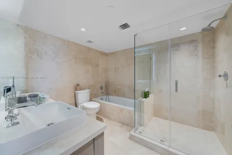 a bathroom with a bathtub shower sink and toilet