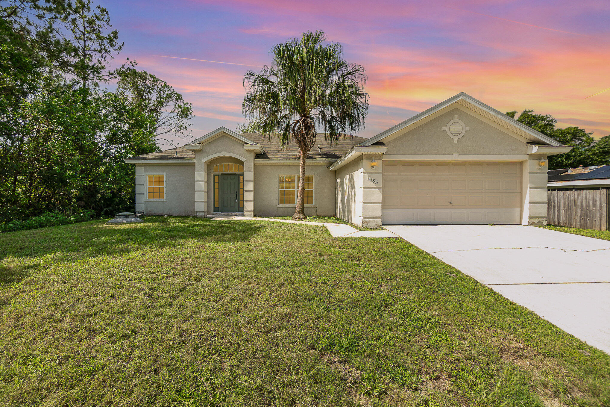 1088 Tupelo Road Southwest Palm Bay, FL 32908 - Photo 1 of 21 a front view of a house with a garden and yard