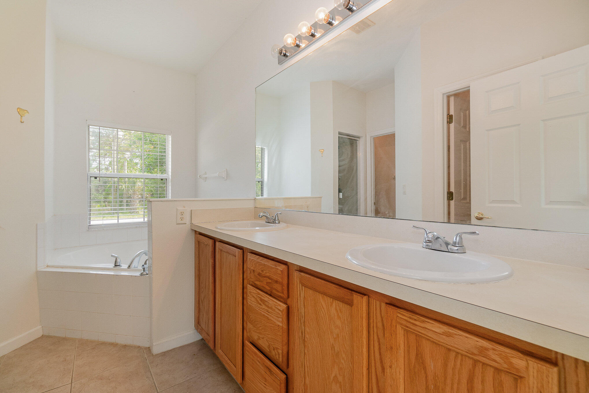 1088 Tupelo Road Southwest Palm Bay, FL 32908 - Photo 16 of 21 a bathroom with a sink double vanity granite tub and a mirror