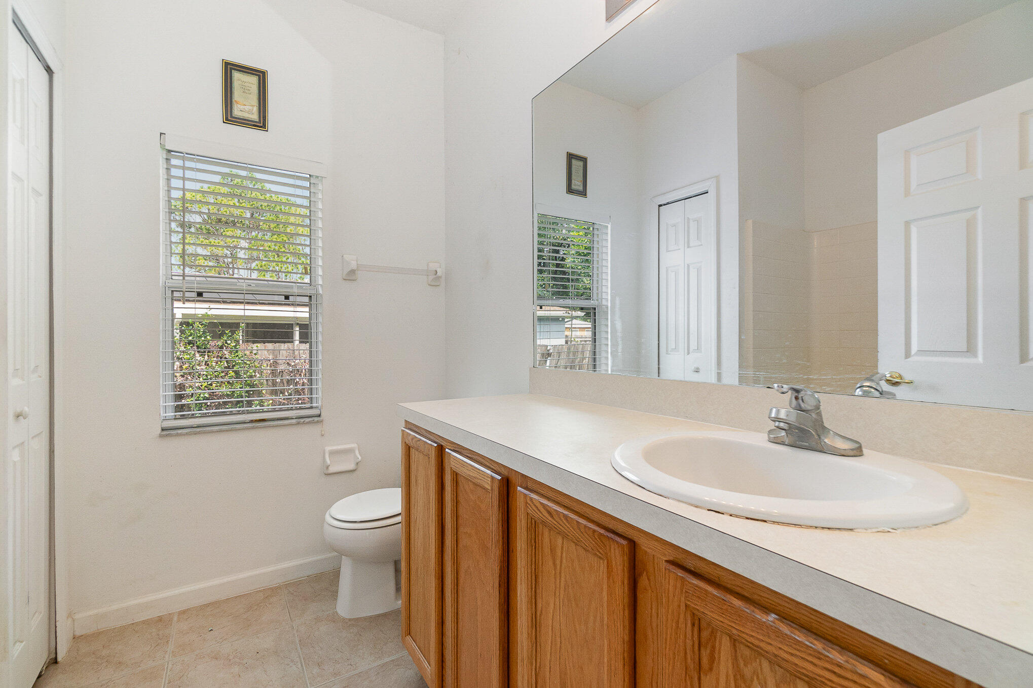 1088 Tupelo Road Southwest Palm Bay, FL 32908 - Photo 19 of 21 a bathroom with a sink a toilet and a window
