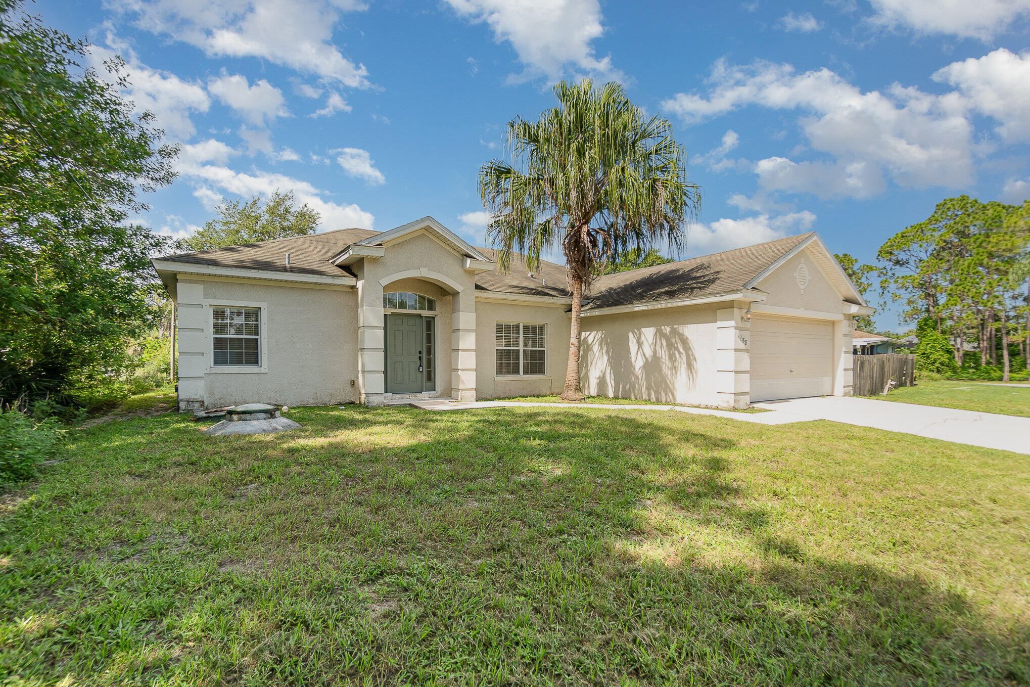1088 Tupelo Road Southwest Palm Bay, FL 32908 - Photo 2 of 21 a front view of a house with a garden