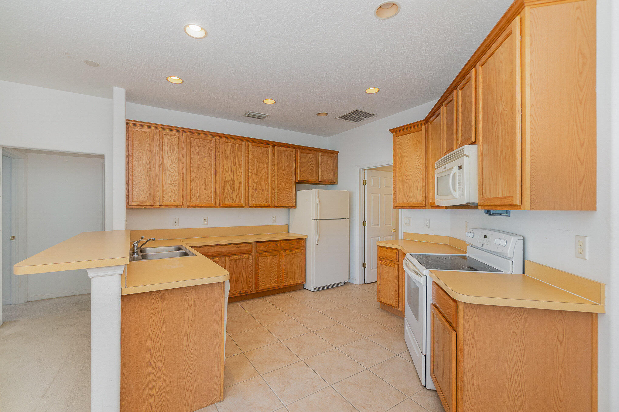 1088 Tupelo Road Southwest Palm Bay, FL 32908 - Photo 9 of 21 a kitchen with a sink a stove and a refrigerator