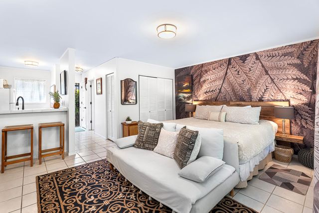 a spacious bedroom with a bed and wooden floor