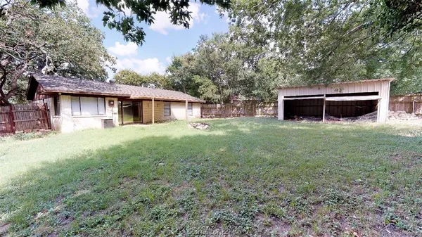 a view of a backyard with large trees